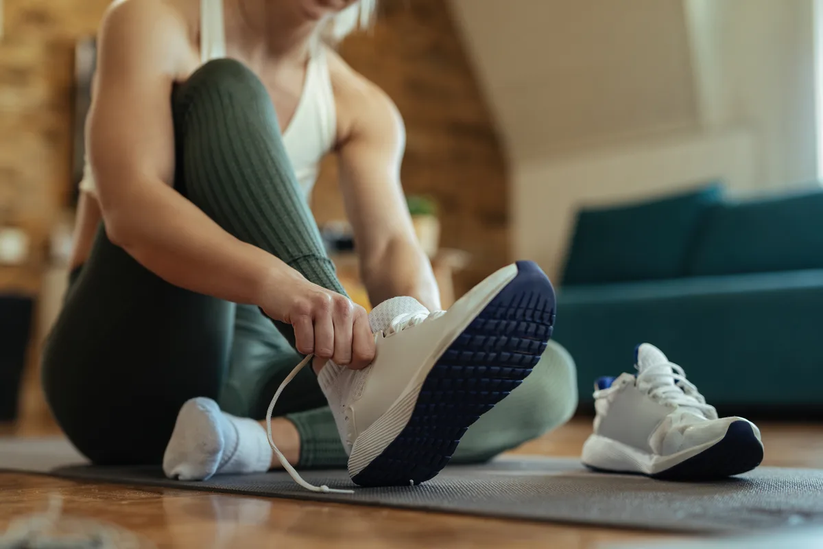 Un deportista se pone las zapatillas deportivas para ir a entrenar